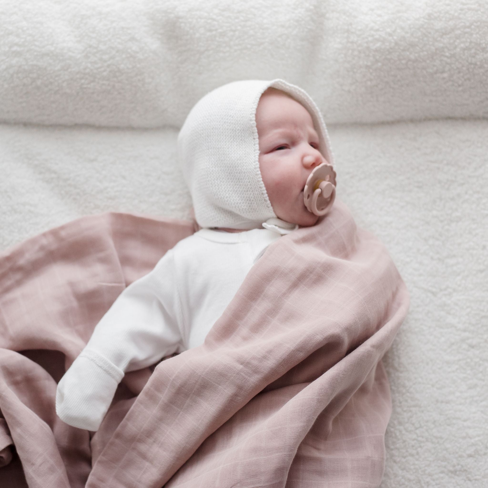 Baby wearing Muslin Swaddle Blanket | Sunset (Organic)