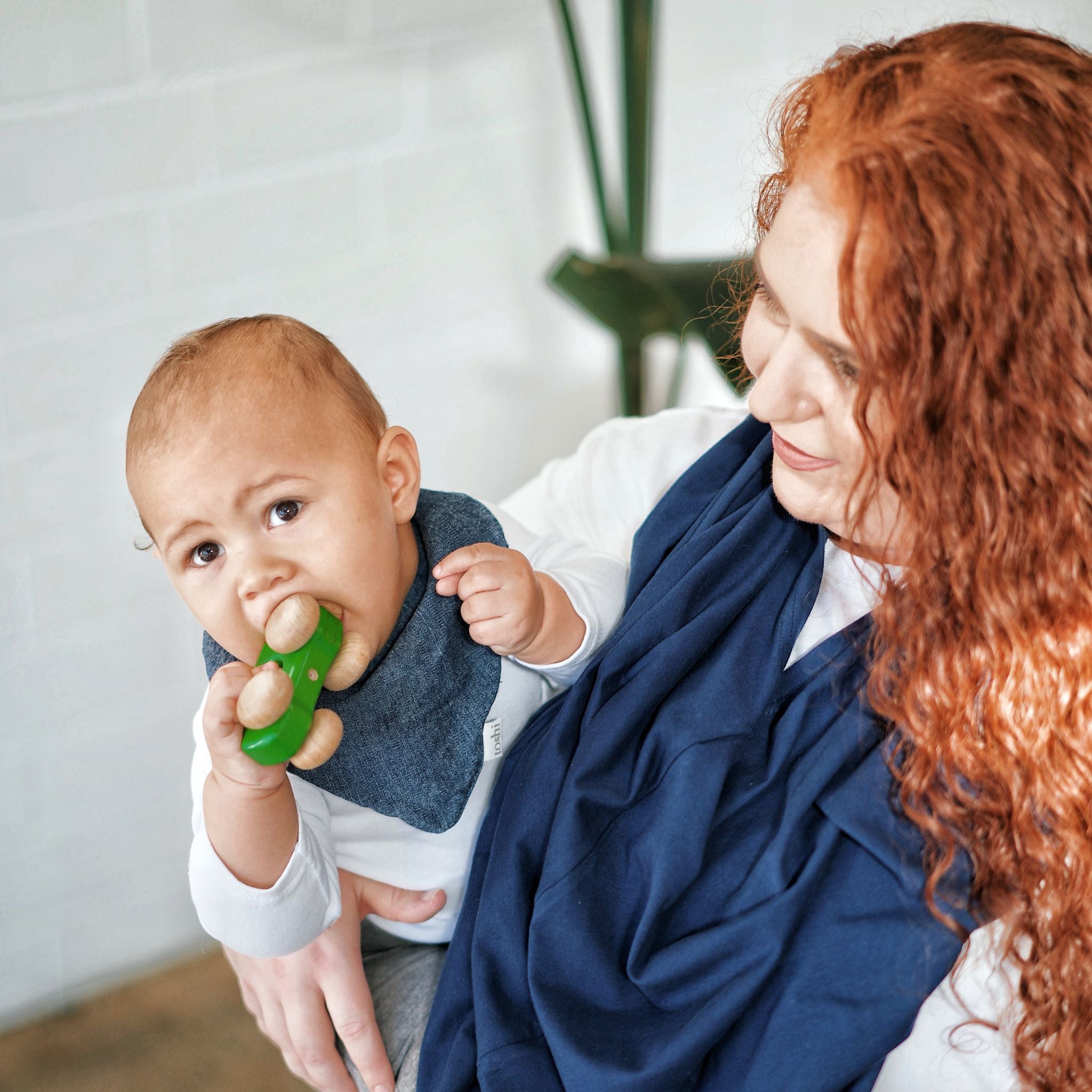 Women wearing 5 in 1 mama cover while holding his baby